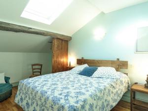 a bedroom with a bed with a blue and white comforter at Gîte de charme avec jardin à Vauvillers - FR-1-583-435 in Vauvillers