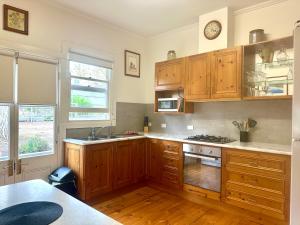 a kitchen with wooden cabinets and a stove top oven at Hill Cottage in Clare
