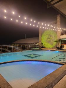 a large swimming pool at night with lights at Kay hotel in Angeles