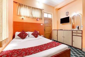 a bedroom with a large bed with red pillows at Hotel Gangotri Pvt Ltd in Bharatpur