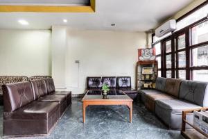 a living room with leather couches and a table at Hotel Gangotri Pvt Ltd in Bharatpur