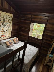 a small bedroom with a bed and a window at Chalé Penedo in Penedo +19 photos