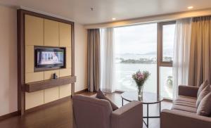 a living room with a tv and a couch and a table at Nha Trang Horizon Hotel in Nha Trang