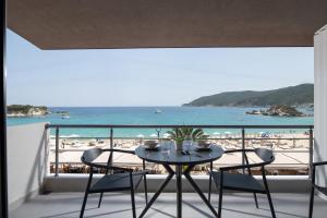 a balcony with a table and chairs and a beach at Suite di Lusso in Kalamitsi +23 photos