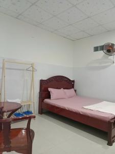 Un dormitorio con una cama y una mesa en una habitación. en Ngân Anh Motel, en Rạch Giá