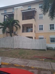 une clôture blanche devant une maison dans l'établissement Royal Exquisite Deluxe, à Kingston