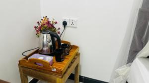 a table with a coffee pot and flowers on it at Sigiriya Danu Homestay in Sigiriya