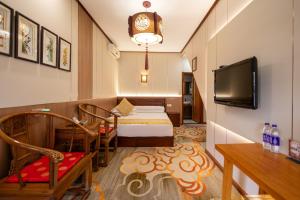 a small room with a bed and a tv at Pingyao Xinglongyi Inn in Pingyao