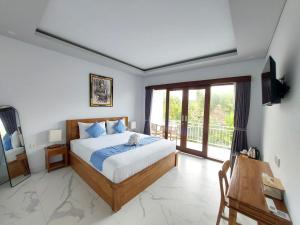 a bedroom with a bed and a large window at PUSPA guest house in Canggu