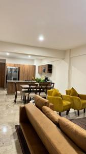 a living room with a couch and yellow chairs at Departamento con vista al mar-rio in Conchal