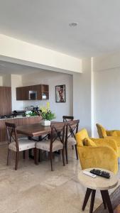 a living room with a table and chairs and a kitchen at Departamento con vista al mar-rio in Conchal