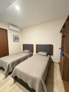 a bedroom with two beds and a dresser at Departamento con vista al mar-rio in Conchal +17 photos