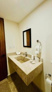 a bathroom with a large marble sink with a mirror at Departamento con vista al mar-rio in Conchal