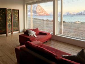 una sala de estar con 2 sofás rojos y una ventana grande en Arctic Family Adventure In Tunstad, Nordnorway, en Myre