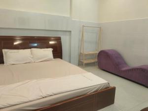 1 dormitorio con cama y silla morada en Ngân Anh Motel, en Rạch Giá