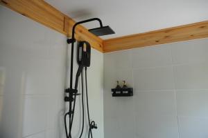 a shower in a bathroom with a shower head at Sea Salt Casa Bang Tao in Ban Thalat Choeng Thale +32 photos