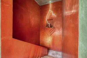 a room with a red wall with a plant on a shelf at Pug Seal Oaxaca in Oaxaca City