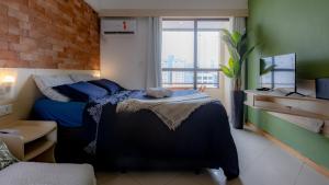Una cama o camas en una habitación de APT 1 Dorm com VAGA - 400m da Praia