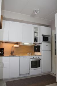 a white kitchen with white cabinets and appliances at Bliss holiday home - Cosy 1 bedroom apartment in Äkäslompolo +10 photos