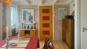 a dining room with a red table and a yellow door at Traditional House With Personal Decor in Hauge +11 photos