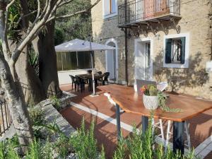 a patio with a table and an umbrella at family Stay in French Riviera in Ventimiglia