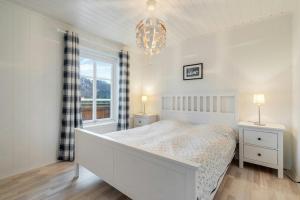 a white bedroom with a bed and a window at High-Standard Cabin In Beautiful Rauland in Rauland