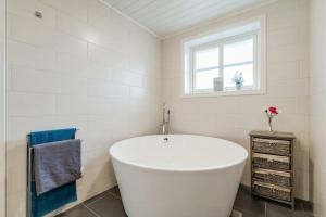 a white tub in a bathroom with a window at High-Standard Cabin In Beautiful Rauland in Rauland +30 photos