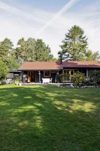 une maison avec une grande pelouse devant dans l'établissement Enjoy Outdoor Life With Orangery And Kitchen, à Græsted