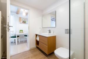 Un baño blanco con inodoro y lavabo. en Red Fountain Studio, en Brasov 15 fotos más