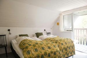 a bedroom with a bed with a yellow blanket at Summer House For The Big Family Close To The Fjord in Agger