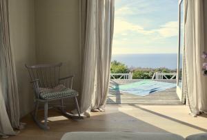 Una mecedora en una habitación con vista al mar. en Boutique Home With Sea View In Vang, en Hasle