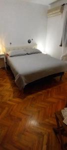 a large bed in a room with a wooden floor at Rest Plus More in Pula
