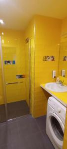a yellow bathroom with a sink and a shower at Rest Plus More in Pula
