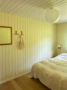 a bedroom with a bed and a mirror on the wall at Summer House Near Ahl Beach And Ebeltoft in Ebeltoft