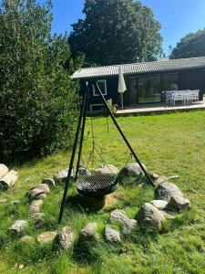 a swing in the grass in a yard at Summer House Near Ahl Beach And Ebeltoft in Ebeltoft
