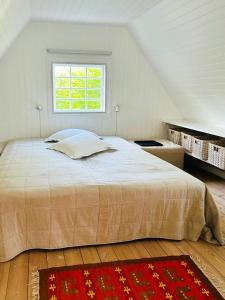 a bedroom with a large bed with a window at Wooden House From 1921 Near The Sea In Gilleleje in Gilleleje +23 photos