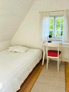 a bedroom with a bed and a desk and a window at Wooden House From 1921 Near The Sea In Gilleleje in Gilleleje