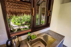 a kitchen sink with a window above a kitchen counter at Red Flower Cottages Homestay in Hoi An +38 photos