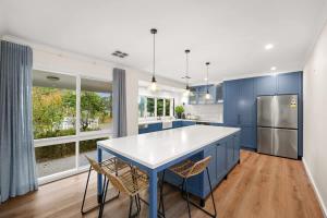 a kitchen with blue cabinets and a table and chairs at Charming Farm Stay 4BR Family Retreat Hastings in Hastings
