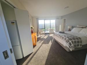 a bedroom with a bed and a large window at Sweet Home in Rolleston