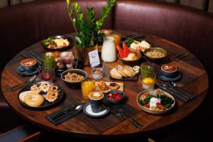 a table with many plates of food on it at Hotel Indigo Brisbane City Centre by IHG in Brisbane