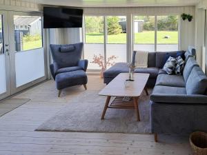 a living room with a couch and two chairs and a table at Cottage Charm Near Lønstrup Lighthouse in Lønstrup