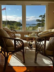a room with two chairs and a table and windows at Summer Cabin With Sea View In Southern Norway in Jordtveit