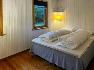 a bed in a room with two pillows on it at Summer Cabin With Sea View In Southern Norway in Jordtveit