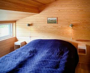 a bedroom with a blue bed in a wooden room at Architect Drawn Holiday Home Near Rondane Park in Høvringen