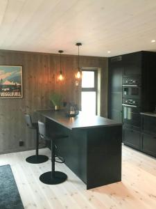 a kitchen with a large black island in a room at Large Cabin Near Hardangervidda With Sunny Veranda in Veggli