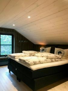 a large bed in a room with a wooden ceiling at Large Cabin Near Hardangervidda With Sunny Veranda in Veggli