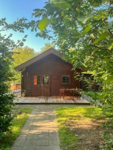 a log cabin with a patio in front of it at Lillebo - Serene Cottage In Nature in Kolind