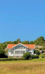 a large house with an orange roof on a field at Farmhouse In Bohuslän Near Sea And Nature in Hamburgsund