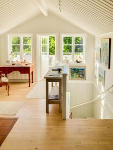 a living room with a table and a piano at Farmhouse In Bohuslän Near Sea And Nature in Hamburgsund